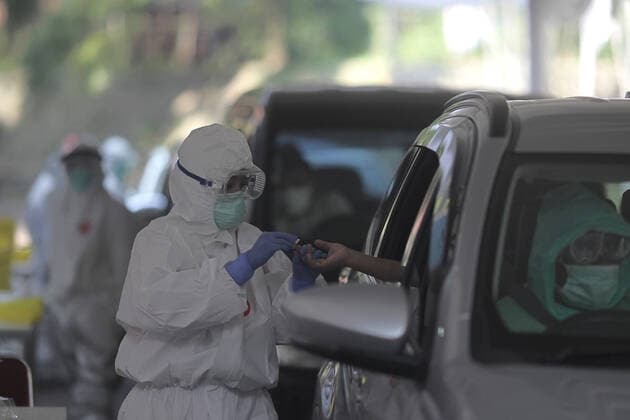 COVID-19 Rapid Test in Bogor, Indonesia - April 4, 2020. A Health workers wearing a protective suit check citizens during the COVID-19 rapid test using the drive thru system in Bogor, West Java, Indonesia, April 4, 2020. The COVID-19 Rapid Test is conducted to speed up the examination process and narrow the spread of Coronavirus (Covid-19) transmission in Bogor, West Java. (Photo by Aditya Saputra INA Photo Agency imago images) 