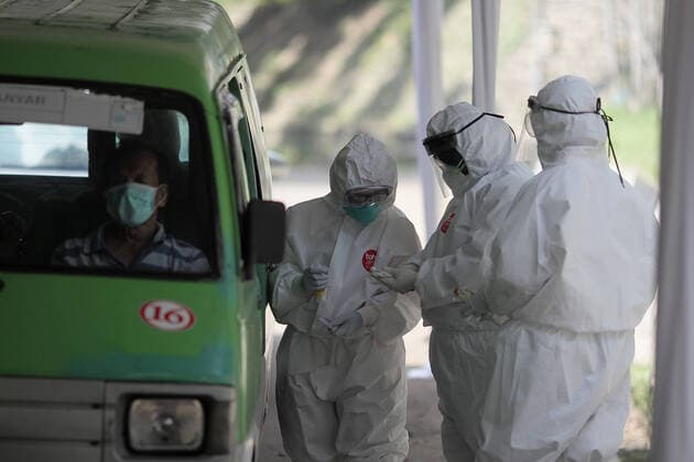 COVID-19 Rapid Test in Bogor, Indonesia - April 4, 2020. A Health workers wearing a protective suit check citizens during the COVID-19 rapid test using the drive thru system in Bogor, West Java, Indonesia, April 4, 2020. The COVID-19 Rapid Test is conducted to speed up the examination process and narrow the spread of Coronavirus (Covid-19) transmission in Bogor, West Java. (Photo by Aditya Saputra INA Photo Agency imago images) 