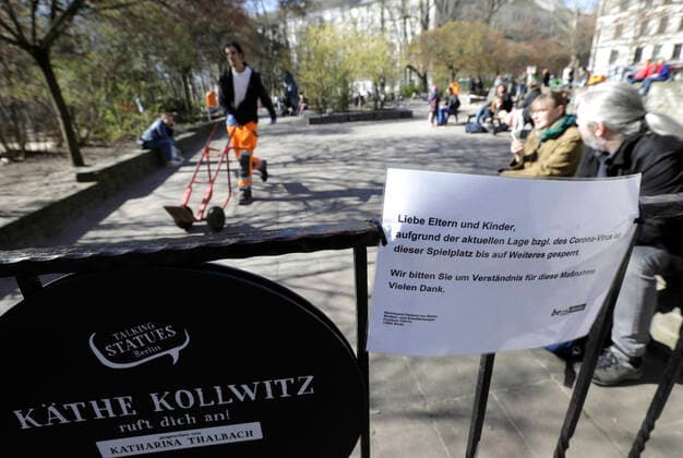 Menschen auf dem gesperrten Kaethe Kollwitz Spielplatz am Kollwitzplatz, waehrend der Corona-Krise,DEU, Berlin, 04.04.2020
