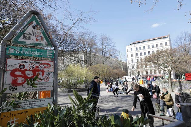 Menschen auf dem gesperrten Kaethe Kollwitz Spielplatz am Kollwitzplatz, waehrend der Corona-Krise,DEU, Berlin, 04.04.2020