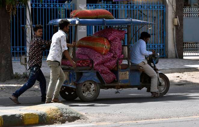 NEW DELHI, INDIA APRIL 4: Vegetable vendors pushing an e-rickshawleaded with onions and potatoes whiile making door to door calls on day eleven of the 21 day nationwide lockdown to check the spreda ofcoronavirus, on April 4, 2020 in New Delhi, India. (Photo by Mohd Zakir Hindustan Times ) India Goes Into 21 Day Lockdown Due To Coronavirus COVID 19