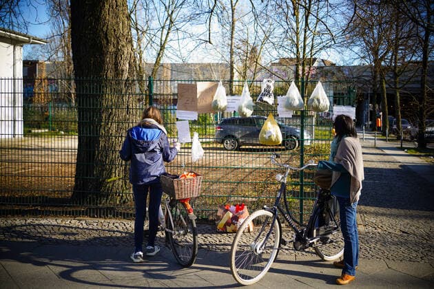 04 04 2020,Berlin,Germany,GER,the city in times of the corona pandemic Two women standing in front of a gift fence with their bicycles Seen at Stuttgarter Platz