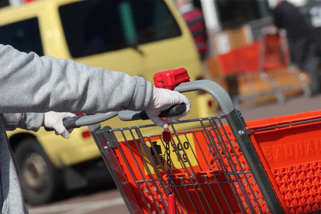 DIY stores will be open again for non-business customers from Saturday, April 4, 2020, after 14 days of not being able to do so, Impressions in Braunschweig Bauhaus shopping cart, hand with protective glove on the handle Braunschweig