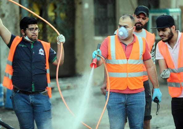 (200404) -- BAGHDAD, April 4, 2020 (Xinhua) -- Volunteers sterilize a street in Baghdad, Iraq, on April 4, 2020. Iraqi Health Ministry on Saturday confirmed two more deaths from COVID-19 and 58 new cases, as the total number of infections climbed to 878. (Xinhua Khalil Dawood) IRAQ-BAGHDAD-COVID-19-NEW CASES 