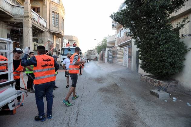 (200404) -- BAGHDAD, April 4, 2020 (Xinhua) -- Volunteers sterilize a street in Baghdad, Iraq, on April 4, 2020. Iraqi Health Ministry on Saturday confirmed two more deaths from COVID-19 and 58 new cases, as the total number of infections climbed to 878. (Xinhua Khalil Dawood) IRAQ-BAGHDAD-COVID-19-NEW CASES 