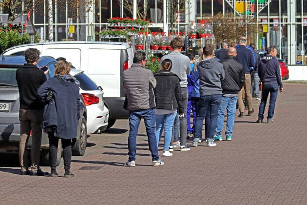 Restrictions due to the coronavirus As a measure to prevent infection with the coronavirus, customers are let into the business premises in a controlled manner by a DIY store in accordance with the contact ban and wait in a row for access Essen North Rhine-Westphalia Germany