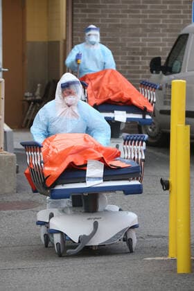 April 4, 2020, New York City, NY, United States: A procession of the dead emerges from the backdoor of Wyckoff Heights Medical Center. Hospital workers push the gurneys carrying the recently deceased to a temporary morgue inside refrigerated container trucks. Their lives were all claimed by COVID-19 or the novel Coronavirus. New York City United States - ZUMAh16_ 20200404_zaf_h16_019 Copyright: xDanxHerrickx