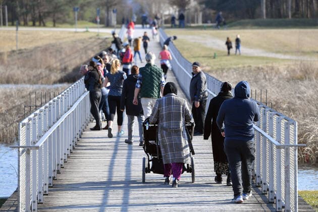 Public life in times of the corona pandemic on 04 04 2020 in the Riemer Park in Munich Families, people, people walking over a bridge at the Riemer See Walkers, walkers The spring weather drives the population to fresh air, always with the necessary distance because of an infection with the corona virus