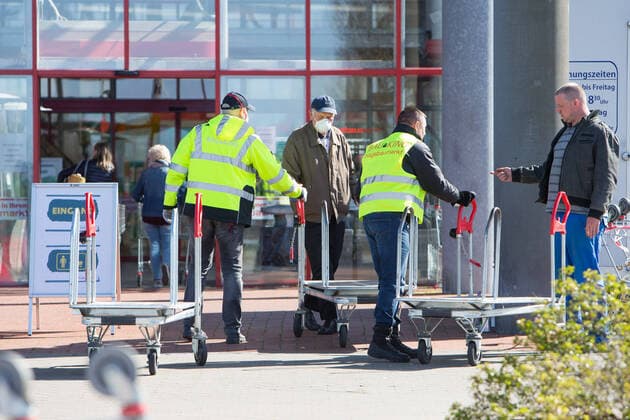 04 04 2020, xtgx, Effects of the Corona Virus in Wolfsburg, Security staff check disinfect shopping trolleys at the entrance of Bau King Hagebaumarkt, Hagebau, DIY store in Vorsfelde Wolfsburg In Lower Saxony, since this Saturday, DIY stores may open again for private persons, but only a certain number of customers with shopping trolleys may enter the store Wolfsburg