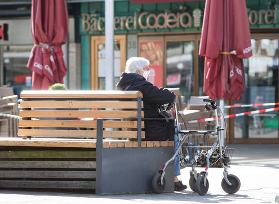 04 04 2020, xtgx, Effects of the Corona Virus in Wolfsburg, a senior citizen with mouth protection sits next to her walker on a bench, symbol photo, symbol image, pensioner, elderly people, risk group, risk patients Wolfsburg