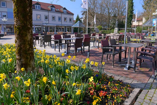 05 04 2020, Shops and restaurants close due to corona virus pandemic in Bad Wörishofen, Yawning empty tables stand without guests at the monument square in the pedestrian zone, the daffodils bloom beautifully in the flowerbed 05 04 2020, Closed restaurants due to corona virus 05 04 2020, Closed restaurants due to corona virus