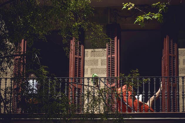 April 5, 2020, Barcelona, Catalonia, Spain: A resident reads a book in the sun on her balcony at the beginning of the fourth week of a nationwide lockdown due to the continuous spread of the virus. Spain registered again over 700 fatalities at the third consecutive day of a falling daily death toll summing up to over 12000 in total. Barcelona Spain - ZUMAo105 20200405_zap_o105_008 Copyright: xMatthiasxOesterlex