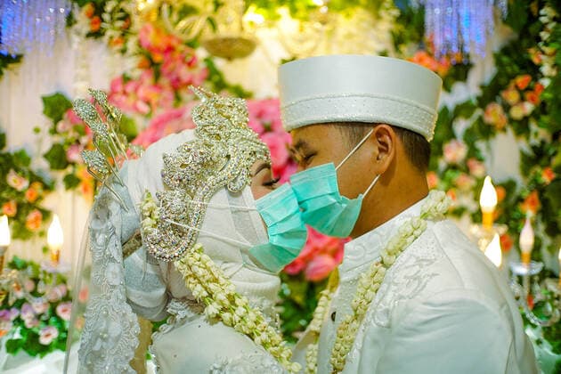 News Bilder des Tages Wedding ceremony, during the COVID-19 coronavirus outbreak in Jakarta - April 5, 2020. A groom and a bride wearing a face mask during wedding ceremony while amid the COVID-19 coronavirus outbreak in Jakarta, Indonesia, on April 5, 2020. (Photo by Ahmad Soleh INA Photo Agency imago images) 