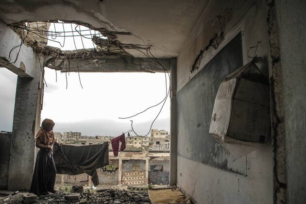 April 5, 2020: The picture shows a displaced Syrian woman spreading clothes in a destroyed classroom as a result of previous bombing by the Syrian regime forces. The displaced live in the destroyed school building due to their displacement from their homes due to the Syrian regime s campaigns in the countryside of Idlib governorate, northern Syria - ZUMAa323 20200405_zip_a323_002 Copyright: xMoawiaxAtrashx