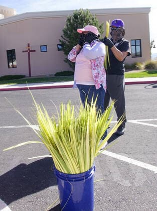 April 5, 2020, Albuquerque, NEW MEXICO, USA: 040520 ..Volunteer Dale Papuyo, right adjusts his wife Mary Papuyo s mask ,before the couple stated to distribute palms outside St. Jude Thaddeus Catholic Church in Paradise Hills as parishioners celebrate Palm Sunday .Photographed on Sunday April 5, 2020.Adolphe Pierre-LouisJournal Albuquerque USA - ZUMAab1_ 20200405_zaf_ab1_001 Copyright: xAlbuquerquexJournalx