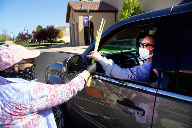 April 5, 2020, Albuquerque, NEW MEXICO, USA: 040520 ..Volunteer Mary Papuyo, left , hands palms to Amanda Brown outside St. Jude Thaddeus Catholic Church in Paradise Hills as parishioners celebrate Palm Sunday .Photographed on Sunday April 5, 2020.Adolphe Pierre-LouisJournal Albuquerque USA - ZUMAab1_ 20200405_zaf_ab1_003 Copyright: xAlbuquerquexJournalx
