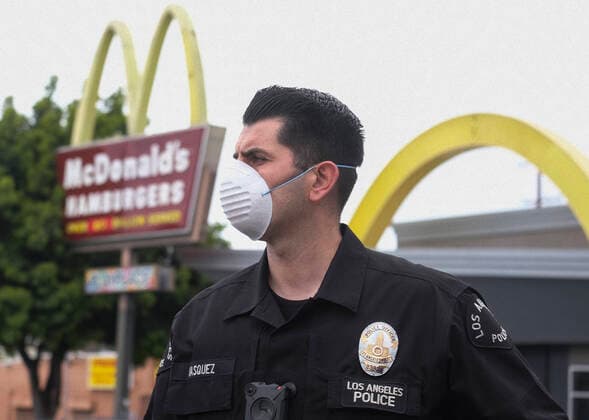 April 5, 2020, Los Angeles, California, U.S: A police officer wearing a face mask as workers take part in a drive-thru strike at a McDonald s restaurant on Sunday, April 5, 2020 in Los Angeles. The workers are demanding a two-week quarantine period, with full pay for a co-worker who tested positive for COVID-19. Los Angeles U.S. - ZUMAc68_ 20200405_zaf_c68_003 Copyright: xRingoxChiux