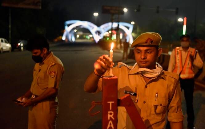 NEW DELHI, INDIA APRIL 5: Delhi along with Noida Police personnel with candles in a show of solidarity and support for frontline workers, on day twelve of the nationwide lockdown to combat coronavirus, at Delhi-Noida border, near Mayur Kunj, on April 5, 2020 in New Delhi, India. Millions of Indians across the country switched off lights at their homes and lit candles and diyas or turned on mobile phone torches on Sunday night, responding to Prime Minister Narendra Modi s appeal to show the nation s collective resolve and solidarity in its fight against coronavirus with this symbolic gesture. (Photo by Mohd Zakir Hindustan Times ) Millions Of Indians Light Candles, Diyas, Turn On Mobile Phone Torches After Prime Minister Modi?s Appeal