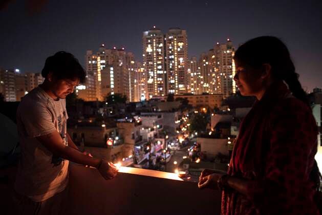 NEW DELHI, INDIA APRIL 5: People light diyas or oil lamps in a show of solidarity and support for frontline workers, on day twelve of the nationwide lockdown to combat coronavirus, at Moti Nagar, on April 5, 2020 in New Delhi, India. Millions of Indians across the country switched off lights at their homes and lit candles and diyas or turned on mobile phone torches on Sunday night, responding to Prime Minister Narendra Modi s appeal to show the nation s collective resolve and solidarity in its fight against coronavirus with this symbolic gesture. (Photo by Sanchit Khanna Hindustan Times ) Millions Of Indians Light Candles, Diyas, Turn On Mobile Phone Torches After Prime Minister Modi?s Appeal