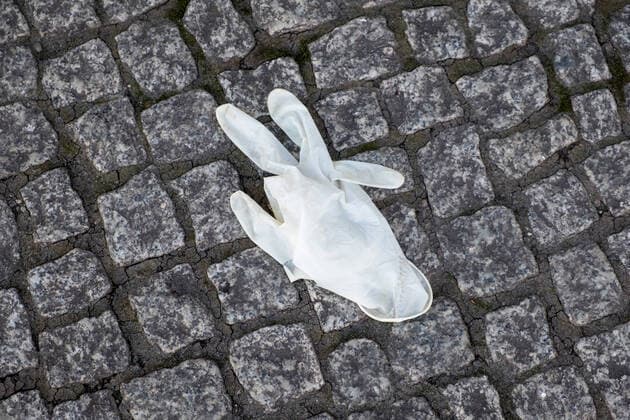 Disused surgical glove lying on the street Coronacrise garbage