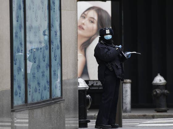 A worker in uniform appears to write a parking ticket on sixth avenue on Palm Sunday In New York City on Sunday, April 5, 2020. Cardinal Timothy Dolan today held a virtual Palm Sunday mass from St. Patrick s Cathedral. Coronavirus cases in the U.S. rose to over 300,000 and the number of deaths rose to more than 8,000 Globally the death toll has been reported at more than 65,000.  NYP20200405112 JOHNxANGELILLO