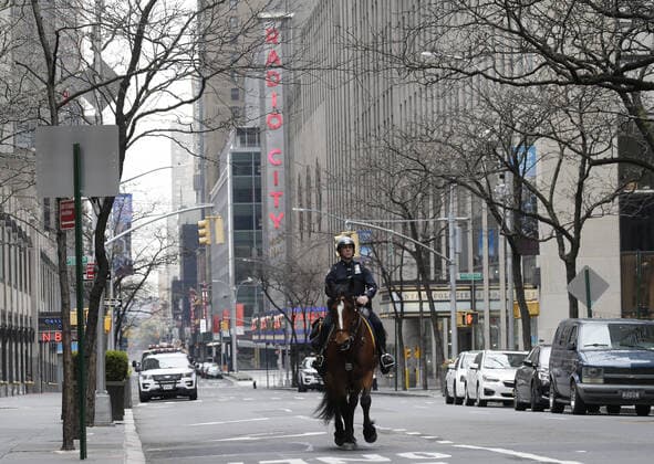 An NYPD police rides on horseback near Radio City Music Hall on Palm Sunday In New York City on Sunday, April 5, 2020. Cardinal Timothy Dolan today held a virtual Palm Sunday mass from St. Patrick s Cathedral. Coronavirus cases in the U.S. rose to over 300,000 and the number of deaths rose to more than 8,000 Globally the death toll has been reported at more than 65,000.  NYP20200405113 JOHNxANGELILLO