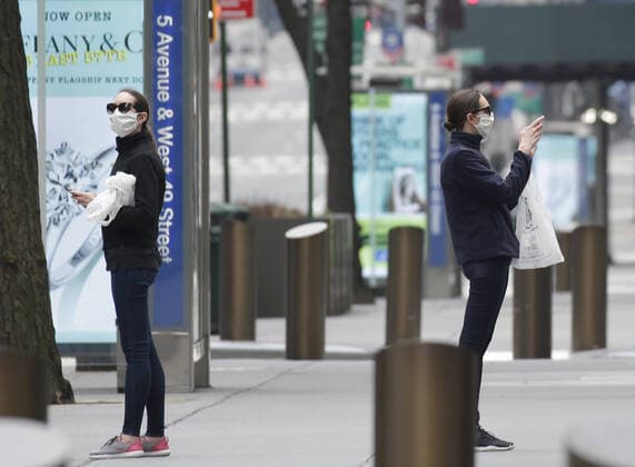 Pedestrians wearing protective face masks walk and take photos on 5th Avenue on Palm Sunday In New York City on Sunday, April 5, 2020. Cardinal Timothy Dolan today held a virtual Palm Sunday mass from St. Patrick s Cathedral. Coronavirus cases in the U.S. rose to over 300,000 and the number of deaths rose to more than 8,000 Globally the death toll has been reported at more than 65,000.  NYP20200405116 JOHNxANGELILLO