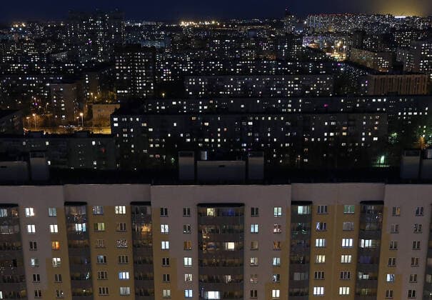 ST PETERSBURG, RUSSIA - APRIL 5, 2020: Lit windows in apartment blocks in Nevsky District. A home isolation order was declared for St Petersburg residents of all ages to restrict movement within the city and reduce the risk of coronavirus contagion, effective since March 30, 2020; a period off work with full pay was extended until April 30 nationwide as part of preventive measures to contain the spread of the COVID-19 infection. Peter Kovalev TASS  TS0D4801