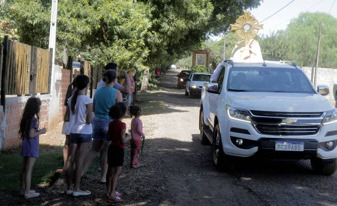 Coronavirus in Brasilien, motorisierte Prozession zum Beginn der Karwoche in Campo Mourao CAMPO MOURÃO, PR - 05.04.2020: COVID 19 ESPANTA FIES NO DOMINGO DE RAMOS - Catholics in Campo Mourão, in the Midwest Region of Paraná, celebrated Palm Sunday? beginning of Holy Week? from the gate into the residences. The faithful placed a green branch on the gates of the houses waiting for the passage of the Most Holy. Due to the recommendation of social isolation due to the Covid-19 pandemic, a disease caused by the coronavirus, a priest held a small procession blessing the homes and people of neighborhoods close to the city center. In the photo, faithful celebrate Palm Sunday from the gate of their homes. x1901705x  DirceuxPortugal