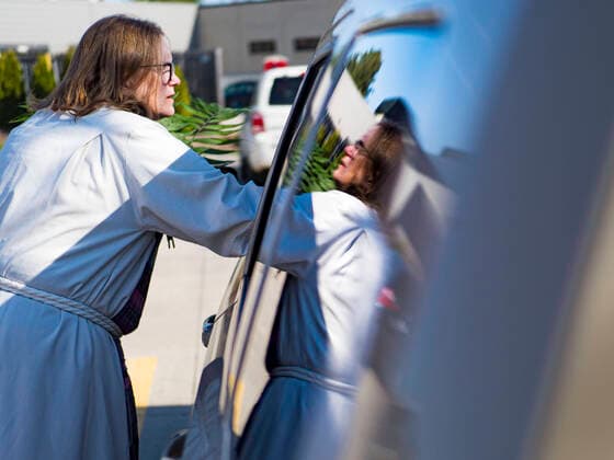 Coronavirus in den USA, Drive-Through Gottesdienst zum Auftakt der Karwoche in Des Moines, Iowa April 5, 2020, Des Moines, Iowa, U.S: Rev. BONNIE PARKER hands out palms during a drive through Palm Sunday service sponsored by Luther Memorial Church on the campus of Grand View University in Des Moines. About 150 people attended the service. They remained in their cars while the ministers read a short passage from the Bible, handed out palms and blessed them. On Sunday, 05 April, Iowa reported 868 confirmed cases of the Novel Coronavirus (SARS-CoV-2) and COVID-19. There have been 22 deaths attributed to COVID-19 in Iowa. Restaurants, bars, movie theaters, places that draw crowds are closed until 30 April. The Governor has not ordered shelter in place but several Mayors, including the Mayor of Des Moines, have asked residents to stay in their homes for all but essential needs. People are being encouraged to practice social distanc - ZUMAk94_ 20200405_zaf_k94_002 Copyright: xJackxKurtzx