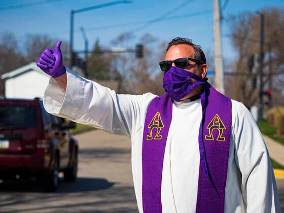 Coronavirus in den USA, Drive-Through Gottesdienst zum Auftakt der Karwoche in Des Moines, Iowa April 5, 2020, Des Moines, Iowa, U.S: Rev. RUSSELL LACKEY blesses people in the neighborhood around Grand View University after a drive through Palm Sunday service sponsored by Luther Memorial Church on the campus of Grand View University in Des Moines. About 150 people attended the service. They remained in their cars while the ministers read a short passage from the Bible, handed out palms and blessed them. On Sunday, 05 April, Iowa reported 868 confirmed cases of the Novel Coronavirus (SARS-CoV-2) and COVID-19. There have been 22 deaths attributed to COVID-19 in Iowa. Restaurants, bars, movie theaters, places that draw crowds are closed until 30 April. The Governor has not ordered shelter in place but several Mayors, including the Mayor of Des Moines, have asked residents to stay in their homes for all but essential needs. People a - ZUMAk94_ 20200405_zaf_k94_020 Copyright: xJackxKurtzx
