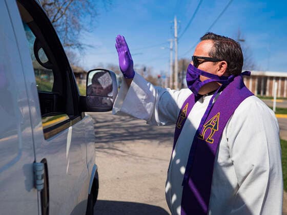Coronavirus in den USA, Drive-Through Gottesdienst zum Auftakt der Karwoche in Des Moines, Iowa April 5, 2020, Des Moines, Iowa, U.S: Rev. RUSSELL LACKEY blesses a person after a drive through Palm Sunday service sponsored by Luther Memorial Church on the campus of Grand View University in Des Moines. About 150 people attended the service. They remained in their cars while the ministers read a short passage from the Bible, handed out palms and blessed them. On Sunday, 05 April, Iowa reported 868 confirmed cases of the Novel Coronavirus (SARS-CoV-2) and COVID-19. There have been 22 deaths attributed to COVID-19 in Iowa. Restaurants, bars, movie theaters, places that draw crowds are closed until 30 April. The Governor has not ordered shelter in place but several Mayors, including the Mayor of Des Moines, have asked residents to stay in their homes for all but essential needs. People are being encouraged to practice social distan - ZUMAk94_ 20200405_zaf_k94_022 Copyright: xJackxKurtzx