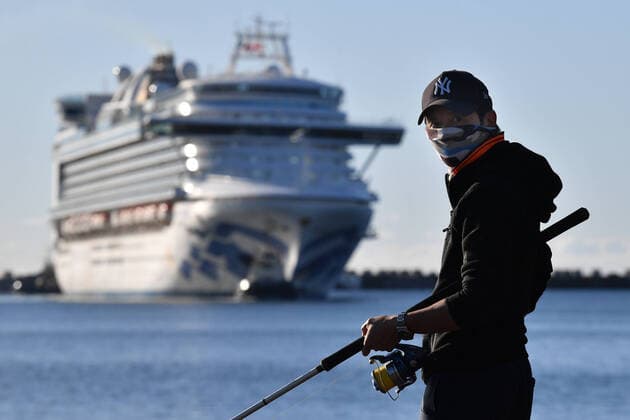 RUBY PRINCESS COVID-19 EVACUATIONS, A fisherman wearing a face mask looks on as the Ruby Princess, with crew only onboard, docks at Port Kembla, Wollongong, Monday, April 6, 2020. A criminal investigation will be launched into how cruise line operator Carnival Australia was allowed to disembark Ruby Princess passengers in Sydney, resulting in several deaths and COVID-19 outbreaks throughout the country. ( NO ARCHIVING, EDITORIAL USE ONLY, NO USE IN BOOKS WITHOUT CONSENT SYDNEY NSW AUSTRALIA Copyright: xDEANxLEWINSx 20200406001461955328