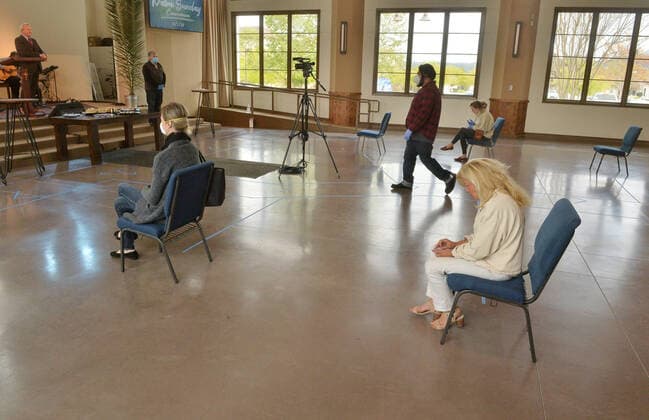 Parishioners practice social distancing guidelines as they partake in the sacrament of communion-not services to kick off Holy Week despite county and state orders restricting non-essential travel at the Godspeak Calvary Chapel in the Newbury Park town of Thousand Oaks, California on Sunday, April 5, 2020. Millions of Christians around the world will spent Palm Sunday watching church service and taking communion from the comfort of their homes as they seek to abide stay-home orders intended to limit the spread of the coronavirus. File  LAP2020040514 JIMxRUYMEN