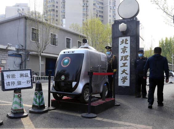 (200406) -- BEIJING, April 6, 2020 -- A member of staff (1st L) checks a 5G unmanned delivery car with its function of temperature measuring at the Beijing Institute of Technology in Beijing, capital of China, April 6, 2020. A 5G unmanned delivery car was put into use at the Beijing Institute of Technology, which can measure the temperature of people entering the campus, recognise facial information, and also can conduct no-touch delivery. ) CHINA-BEIJING-CAMPUS-UNMANNED DELIVERY CAR (CN) RenxChao 