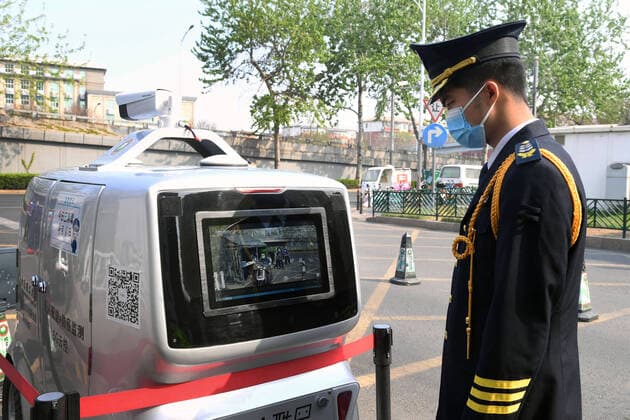 (200406) -- BEIJING, April 6, 2020 -- A member of staff checks a 5G unmanned delivery car with its function of temperature measuring at the Beijing Institute of Technology in Beijing, capital of China, April 6, 2020. A 5G unmanned delivery car was put into use at the Beijing Institute of Technology, which can measure the temperature of people entering the campus, recognise facial information, and also can conduct no-touch delivery. ) CHINA-BEIJING-CAMPUS-UNMANNED DELIVERY CAR (CN) RenxChao 