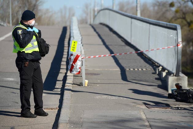 KYIV, UKRAINE - APRIL 06, 2020 - Police officer blocks the passage through the Venetian walking bridge that leads to the outdoor sports ground, Kyiv, capital of Ukraine. Police block entrance to Hydropark sports ground in capital  Copyright: xYevhenxKotenkox