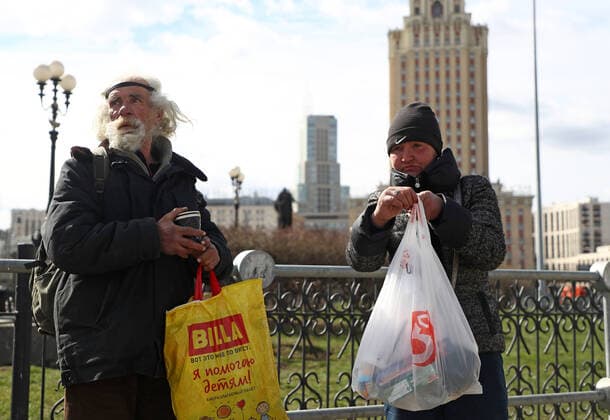 Coronavirus in Russland, Initiative verteilt Essen an BedÃ¼rftige in Moskau MOSCOW, RUSSIA - APRIL 6, 2020: Homeless people hold bags of food and essentials left in Komsomolskaya Square as part of the You Are Not Alone initiative held by the Nochlezhka charity in Moscow and St Petersburg to support homeless people during the COVID-19 pandemic. Under the initiative, such bags are handed out to homeless people or left for them in public places. Anton Novoderezhkin TASS  TS0D48DA