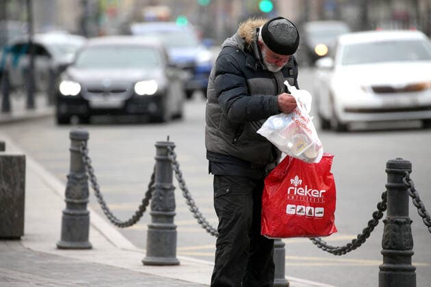 ST PETERSBURG, RUSSIA - APRIL 6, 2020: A homeless man checks a bag of food and essential supplies left by volunteers of the Nochlezhka charity as part of the initiative held in St Petersburg and Moscow to support homeless people during the COVID-19 pandemic. Under the initiative, such bags are handed out to homeless people or left for them in public places. Peter Kovalev TASS  TS0D48D1