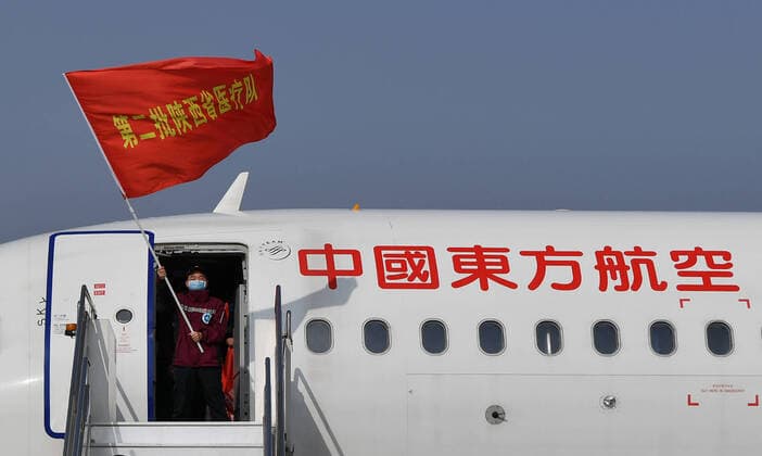 (200406) -- XI AN, April 6, 2020 -- Ma Xiancang, head of a medical team supporting virus-hit Hubei Province, waves the team flag as he disembarks from the plane at Xi an Xianyang International Airport in northwest China s Shaanxi Province, April 6, 2020. A batch of 121 medical workers returned to Shaanxi on Monday after aiding the fight against the COVID-19 in central China s Hubei Province. ) CHINA-SHAANXI-XI AN-MEDICAL WORKERS-RETURN FROM HUBEI (CN) LiuxXiao 