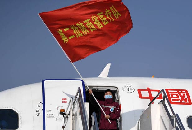 (200406) -- XI AN, April 6, 2020 -- Ma Xiancang, head of a medical team supporting virus-hit Hubei Province, waves the team flag as he disembarks from the plane at Xi an Xianyang International Airport in northwest China s Shaanxi Province, April 6, 2020. A batch of 121 medical workers returned to Shaanxi on Monday after aiding the fight against the COVID-19 in central China s Hubei Province. ) CHINA-SHAANXI-XI AN-MEDICAL WORKERS-RETURN FROM HUBEI (CN) LixYibo 