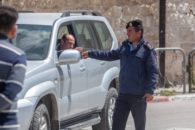 (200406) -- BETHLEHEM, April 6, 2020 (Xinhua) -- A Palestinian police officer seizes a car key during a campaign to seize drivers who violate the emergency law in the West Bank city of Bethlehem, April 6, 2020. Palestine declared on Monday the full lockdown of four villages in the West Bank, as the COVID-19 cases in Palestine has climbed to 252. (Photo by Luay Sababa Xinhua) MIDEAST-BETHLEHEM-COVID-19 