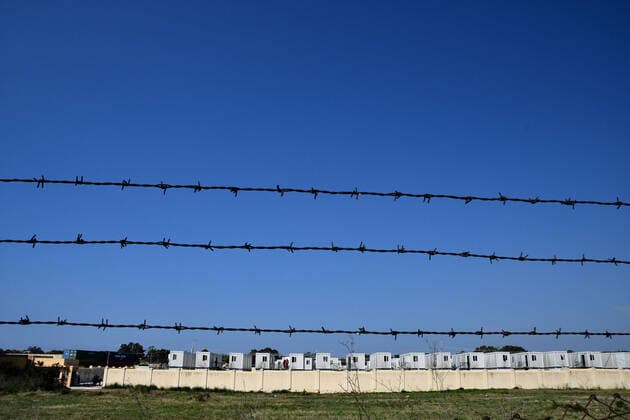(200406) -- BIRZEBBUGA, April 6, 2020 -- Tight security is placed around Hal Far open center in Birzebbuga, Malta, April 6, 2020. All the 1,000 residents at one of Malta s open centers have been placed on a mandatory 14-day lockdown after eight of them tested positive for coronavirus, Health Minister Chris Fearne announced on Sunday. He said the decision was taken following a risk assessment which revealed that the danger that the virus is passed to people outside the center would grow unless it is contained. (Photo by Xinhua) MALTA-BIRZEBBUGA-OPEN CENTER-LOCKDOWN JonathanxBorg 