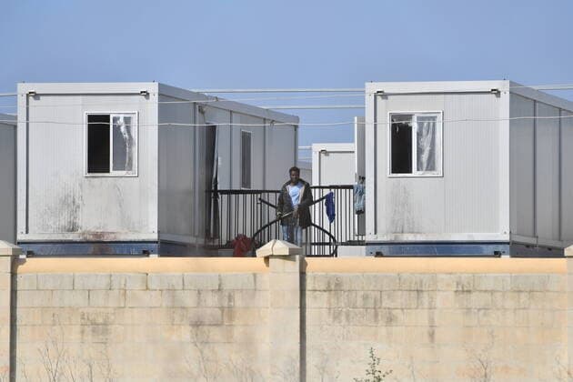 (200406) -- BIRZEBBUGA, April 6, 2020 -- A resident is seen at Hal Far open center in Birzebbuga, Malta, April 6, 2020. All the 1,000 residents at one of Malta s open centers have been placed on a mandatory 14-day lockdown after eight of them tested positive for coronavirus, Health Minister Chris Fearne announced on Sunday. He said the decision was taken following a risk assessment which revealed that the danger that the virus is passed to people outside the center would grow unless it is contained. (Photo by Xinhua) MALTA-BIRZEBBUGA-OPEN CENTER-LOCKDOWN JonathanxBorg 