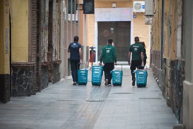 April 6, 2020, Malaga, Spain: Workers of a supermarket carry shopping carts with food during a Holy Monday in downtown city..The traditional Easter celebration has been cancelled in Spain. Believers live an unusual Holy Week in their homes, for that reason many people decorate their balconies or place decorative statues of Christ in their shops and stores. After the alarm state and lockdown in the country by COVID-19 coronavirus all people are enclosed in their homes following the confinement decreed by the Spanish government and which will be extended for more 15 days until 26 April. Malaga Spain - ZUMAs197 20200406_zaa_s197_036 Copyright: xJesusxMeridax
