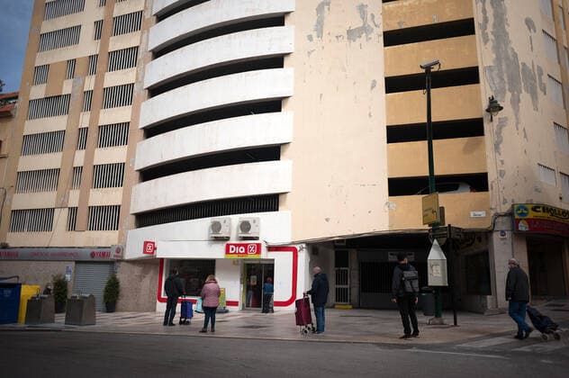 April 6, 2020, Malaga, Spain: People stand in a queue while keeping social distance outside a supermarket in downtown city during a Holy Monday.The traditional Easter celebration has been cancelled in Spain. Believers live an unusual Holy Week in their homes, for that reason many people decorate their balconies or place decorative statues of Christ in their shops and stores. After the alarm state and lockdown in the country by COVID-19 coronavirus all people are enclosed in their homes following the confinement decreed by the Spanish government and which will be extended for more 15 days until 26 April. Malaga Spain - ZUMAs197 20200406_zaa_s197_039 Copyright: xJesusxMeridax