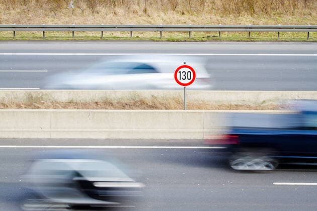 Tempo 130 auf deutschen Autobahnen, allgemeines Tempolimit, Geschwindigkeitsbegrenzungsschild 130 auf Autobahn mit vorbeifahrendem Auto *** Speed 130 on German motorways, general speed limit, speed limit sign 130 on motorways with passing car 1083401747
