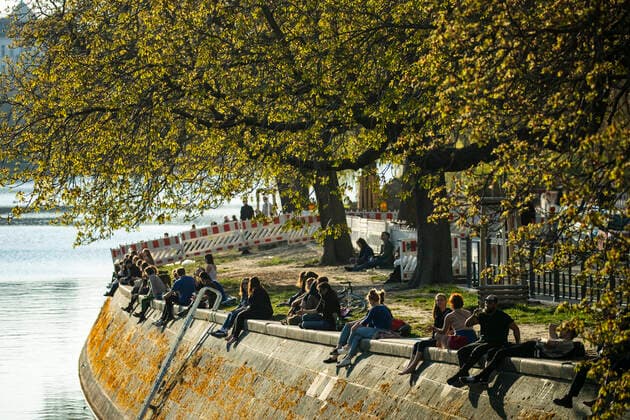 People enjoy the sun at Landwehrkanal in Berlin on April 6, 2020 To slow down the spread of the coronavirus SARS CoV 2, the federal and state governments decided on further restrictions After museums, theatres, sporting events etc. were banned, further tightened measures