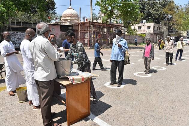 NEW DELHI, INDIA - APRIL 6: People queue at a food distribution while maintaining distance, on day thirteen of the 21-day nationwide lockdown to check the spread of coronavirus at RK Ashram on April 6, 2020 in New Delhi, India. (Photo by Sanchit Khanna Hindustan Times) Government And NGOs Provide Food To Homeless And Poor Amid Lockdown To Prevent Covid-19