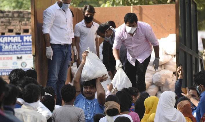 NEW DELHI, INDIA - APRIL 6: SDMC officials distribute raw food materials, on day thirteen of the 21-day nationwide lockdown to check the spread of coronavirus, at Masudpur village at Vasant Kunj on April 6, 2020 in New Delhi, India. (Photo by Sanchit Khanna Hindustan Times) Government And NGOs Provide Food To Homeless And Poor Amid Lockdown To Prevent Covid-19